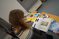 Studentin besiht sich die Bücher beim Büchertisch