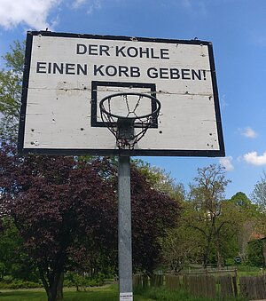 Basketballkorb mit der Schildaufschrift: "Der Kohle einen Korb geben""